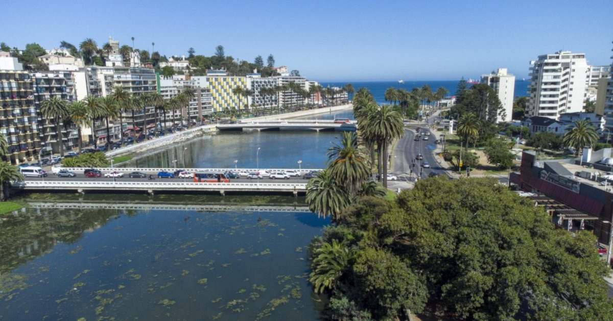 El estero Marga Marga a su paso por Viña del Mar, con sus puentes, las palmeras y el mar al fondo.